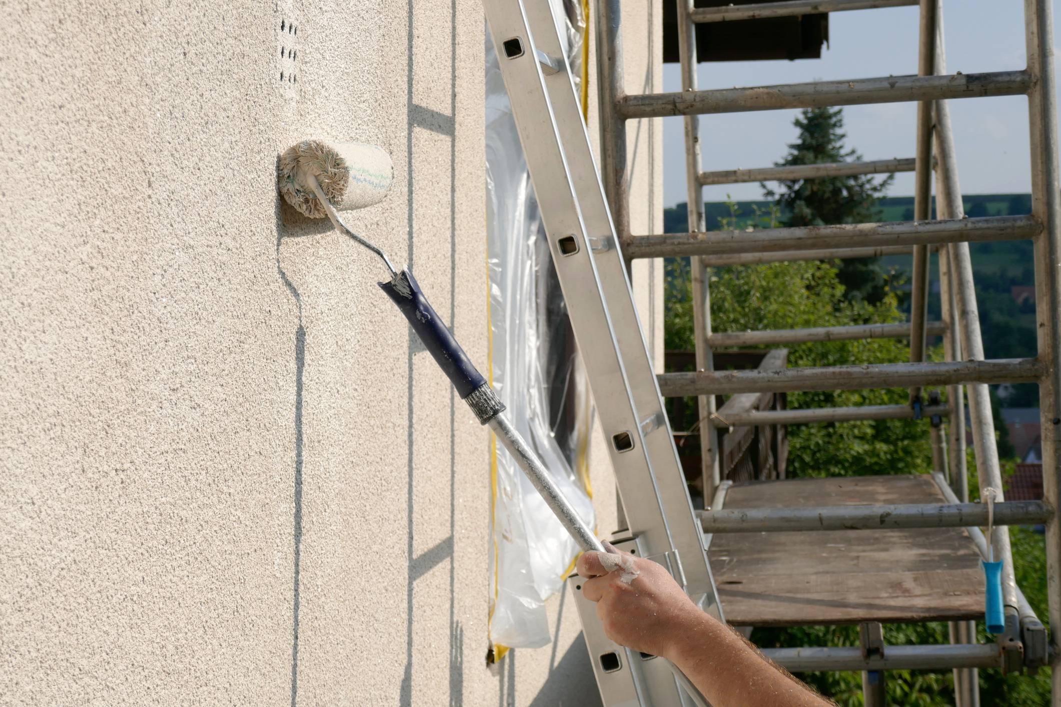 Façadier appliquant un revêtement sur façade extérieure